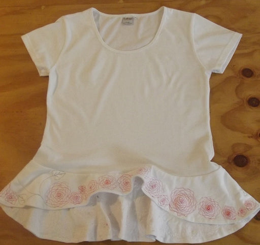 flat lay of white embroidered cotton womens top with peplum