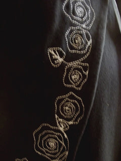 close up of white embroidery on black embroidered cotton wrap dress
