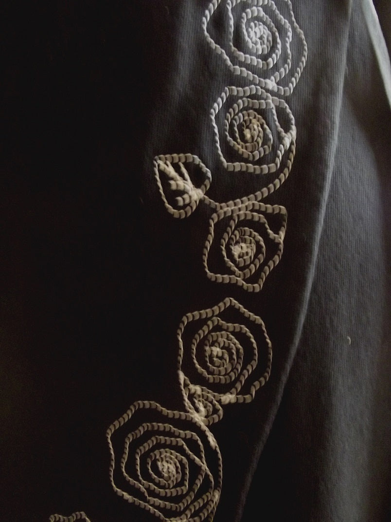 close up of white embroidery on black embroidered cotton wrap dress
